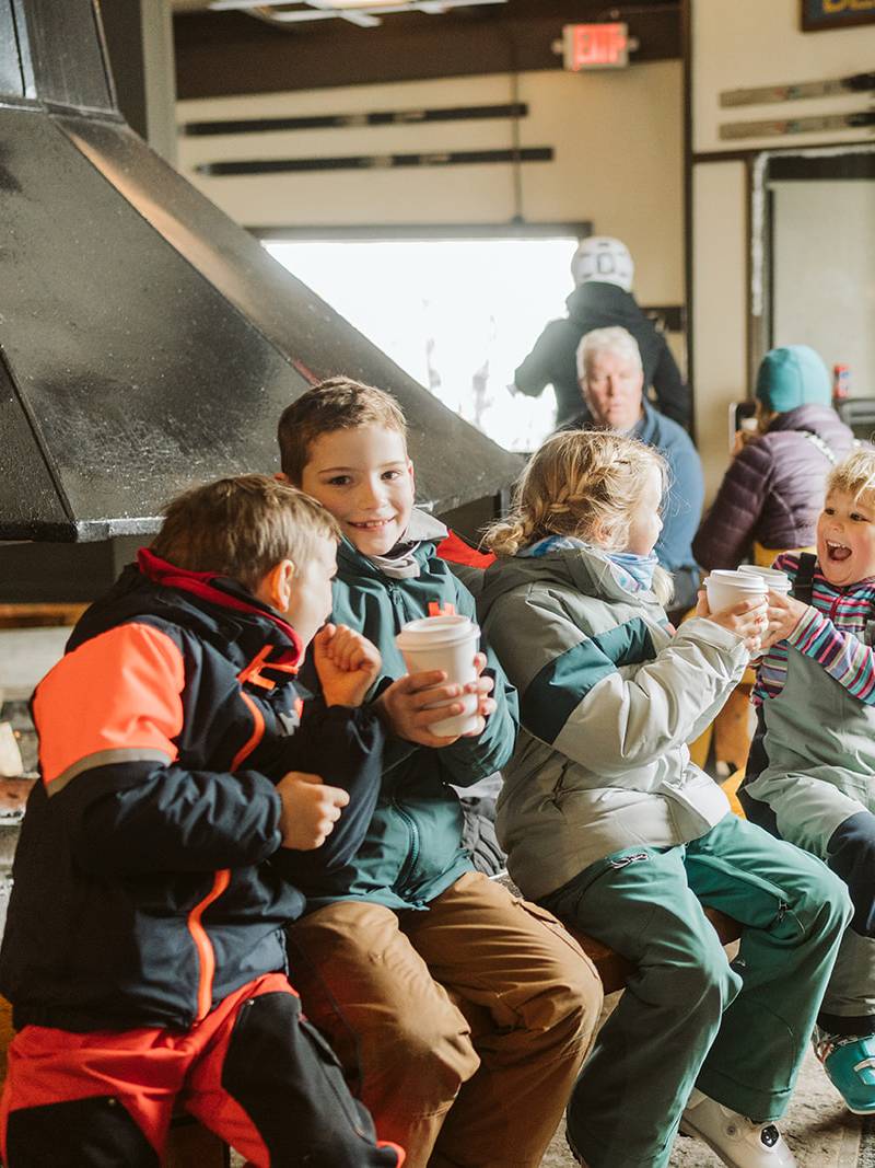 Kids sitting by the fire inside Eagle's Nest