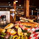 Spread of food showing a salad, grinder, and beer at Trophy Room Pizzeria & Pub at Boyne Mountain