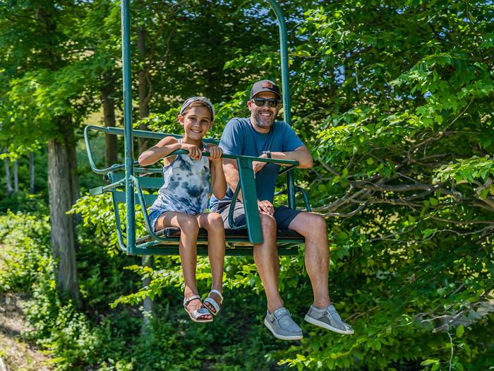 Girl and dad riding the scenic chairlift