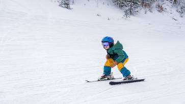 Young boy shredding down the ski hill