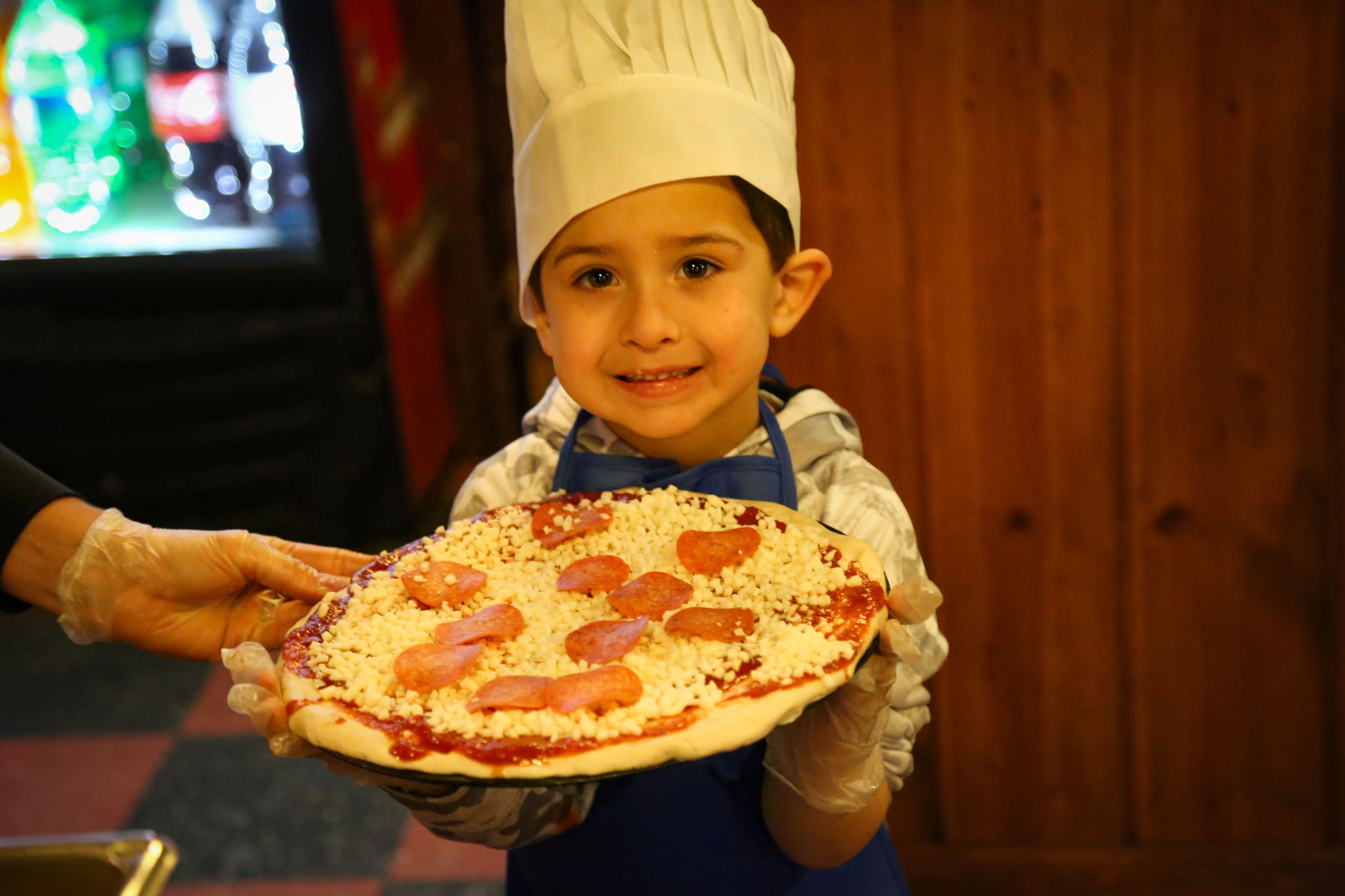 kid at pizza making class