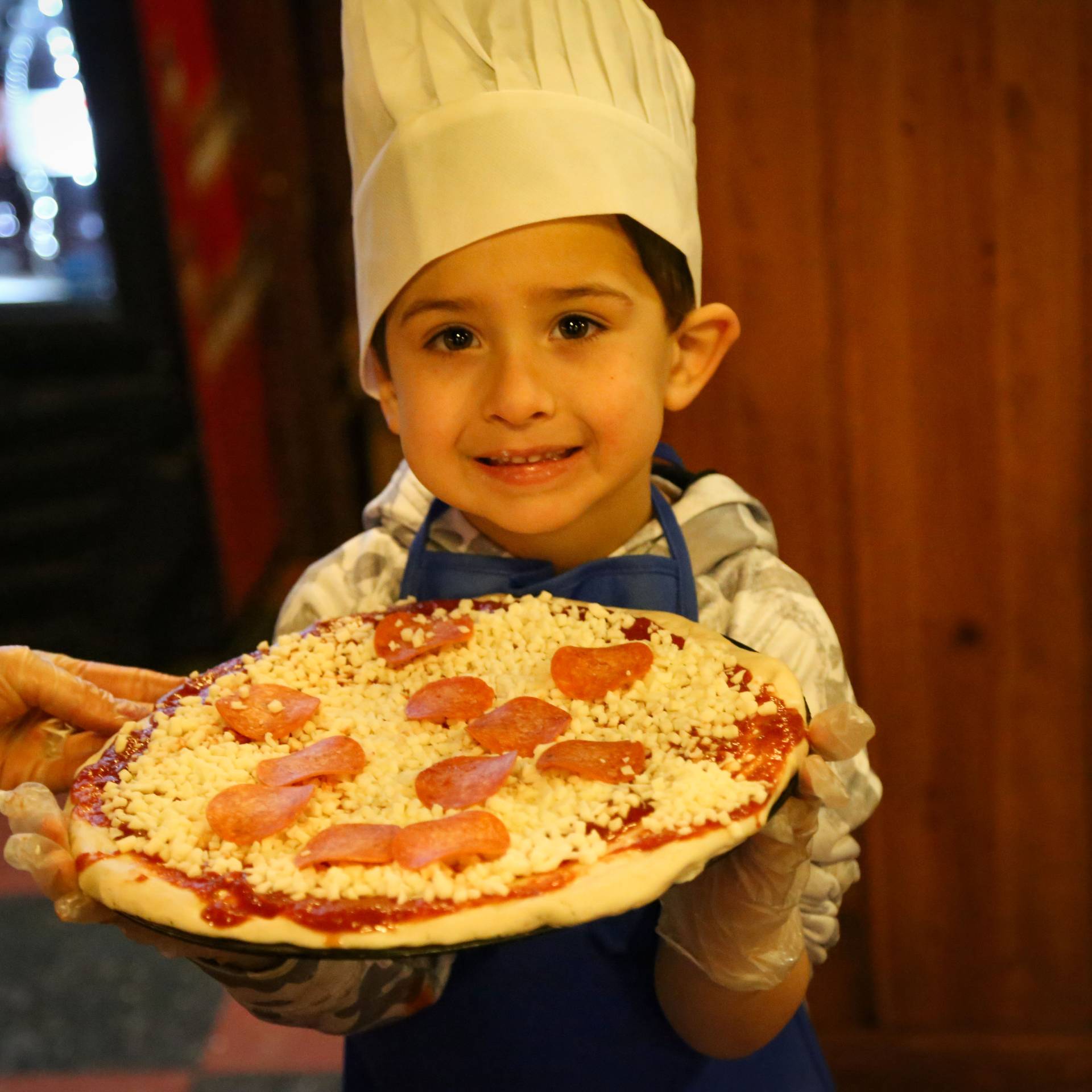 kid at pizza making class