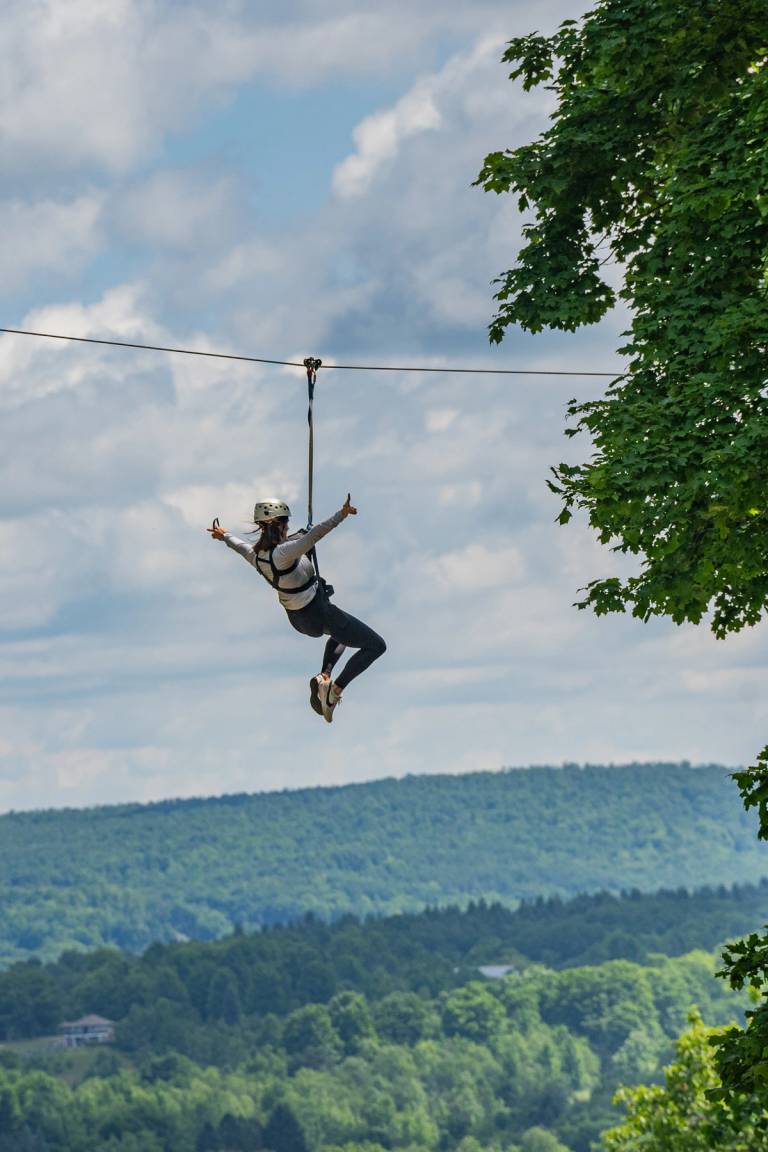 person riding zipline at boyne mountain