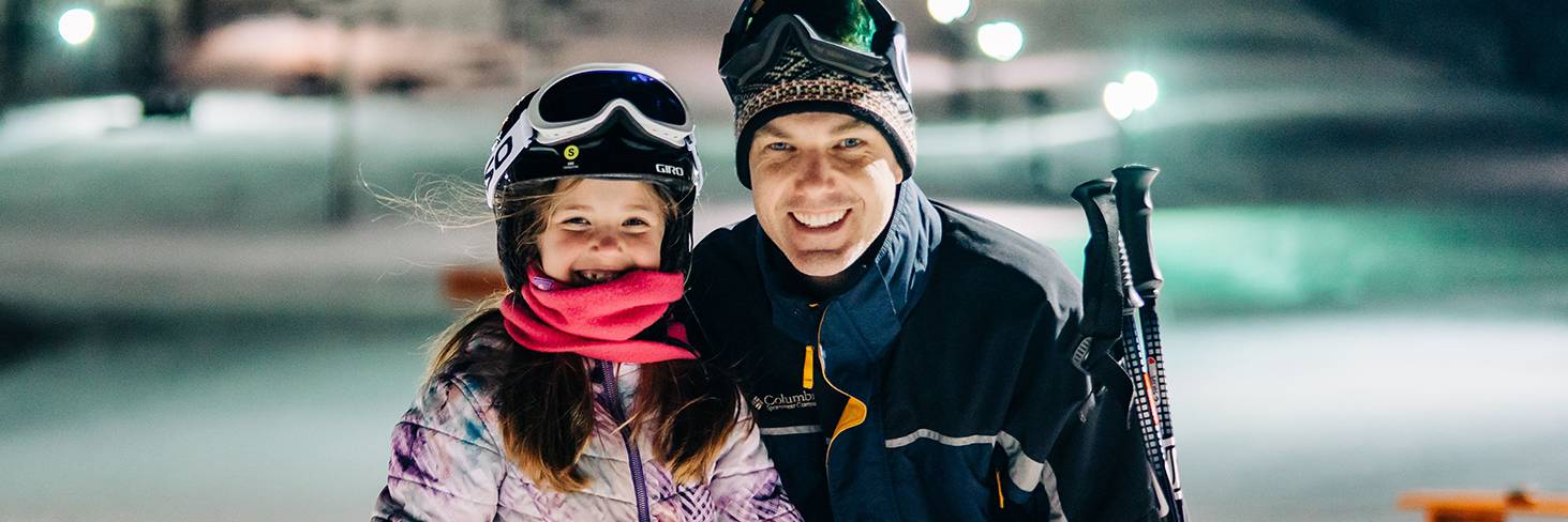 Father and daughter on base of hill