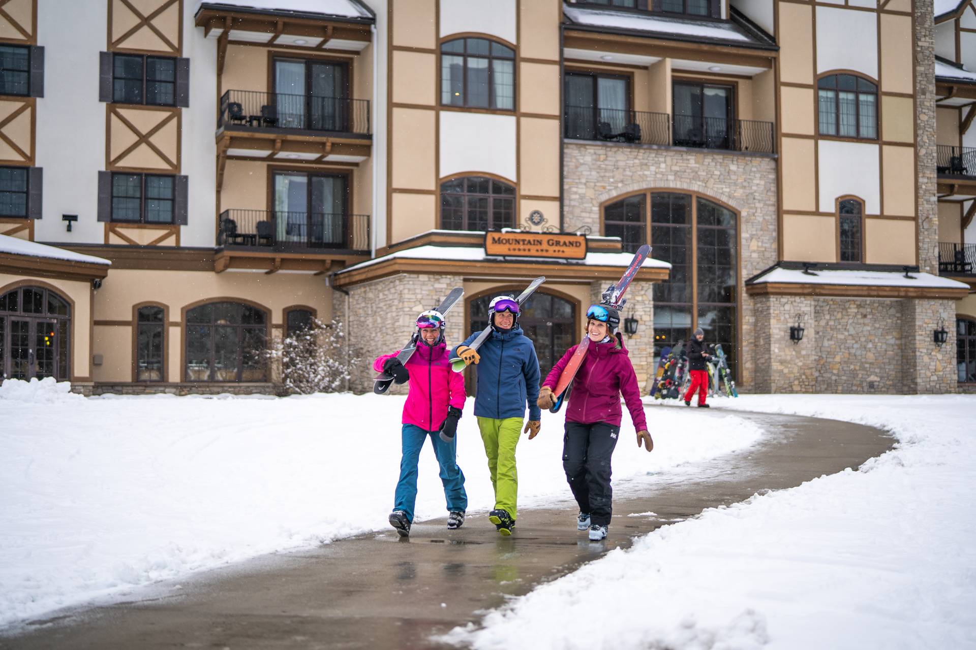 Ladies walking to the slopes with skis from the Mountain Grand Lodge and Spa
