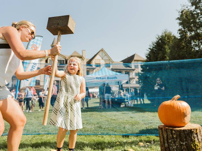 mother and daughter pumpkin smashing