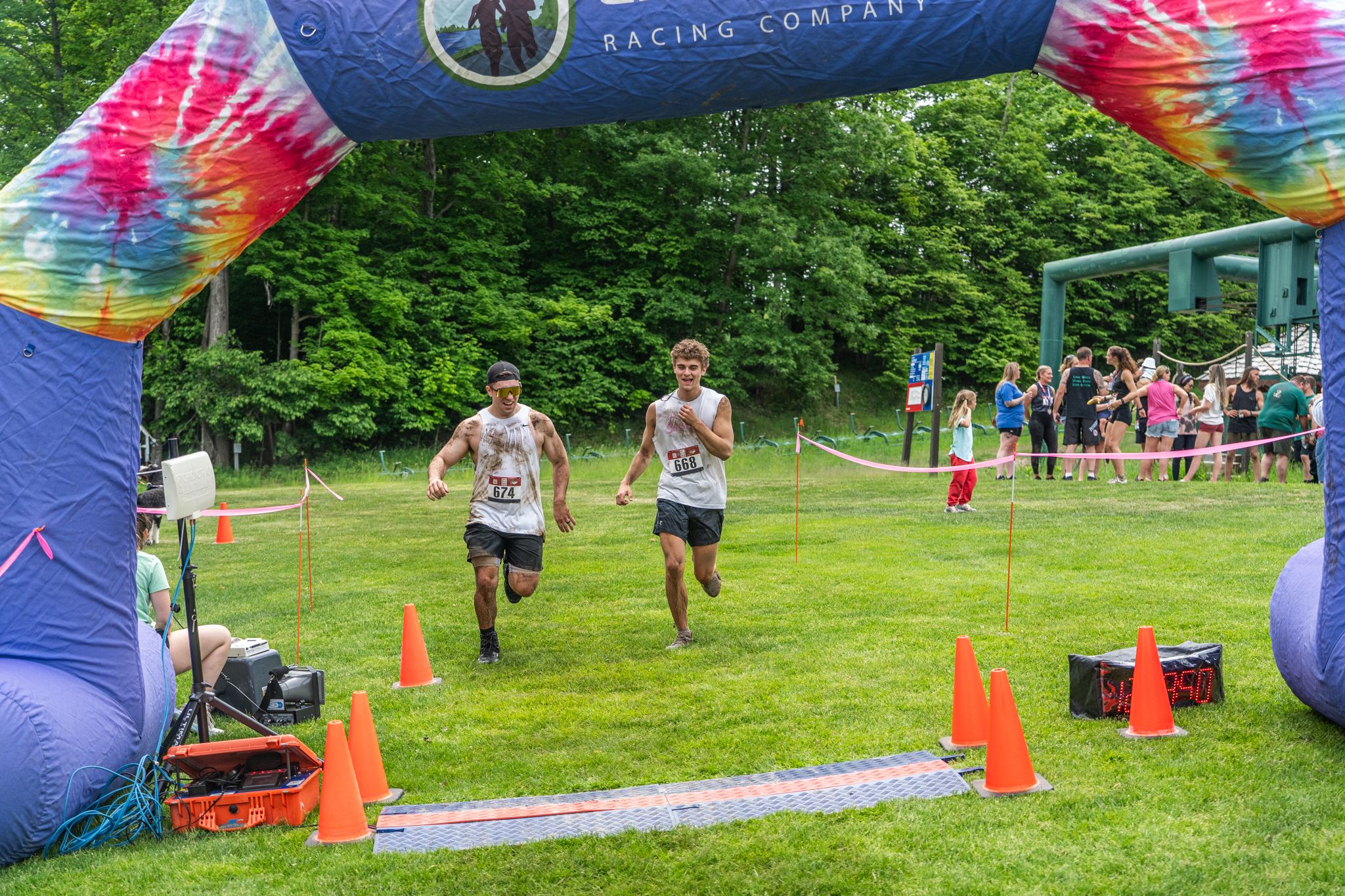 Two guys running through the finish line of the Dirty Dog Dash.