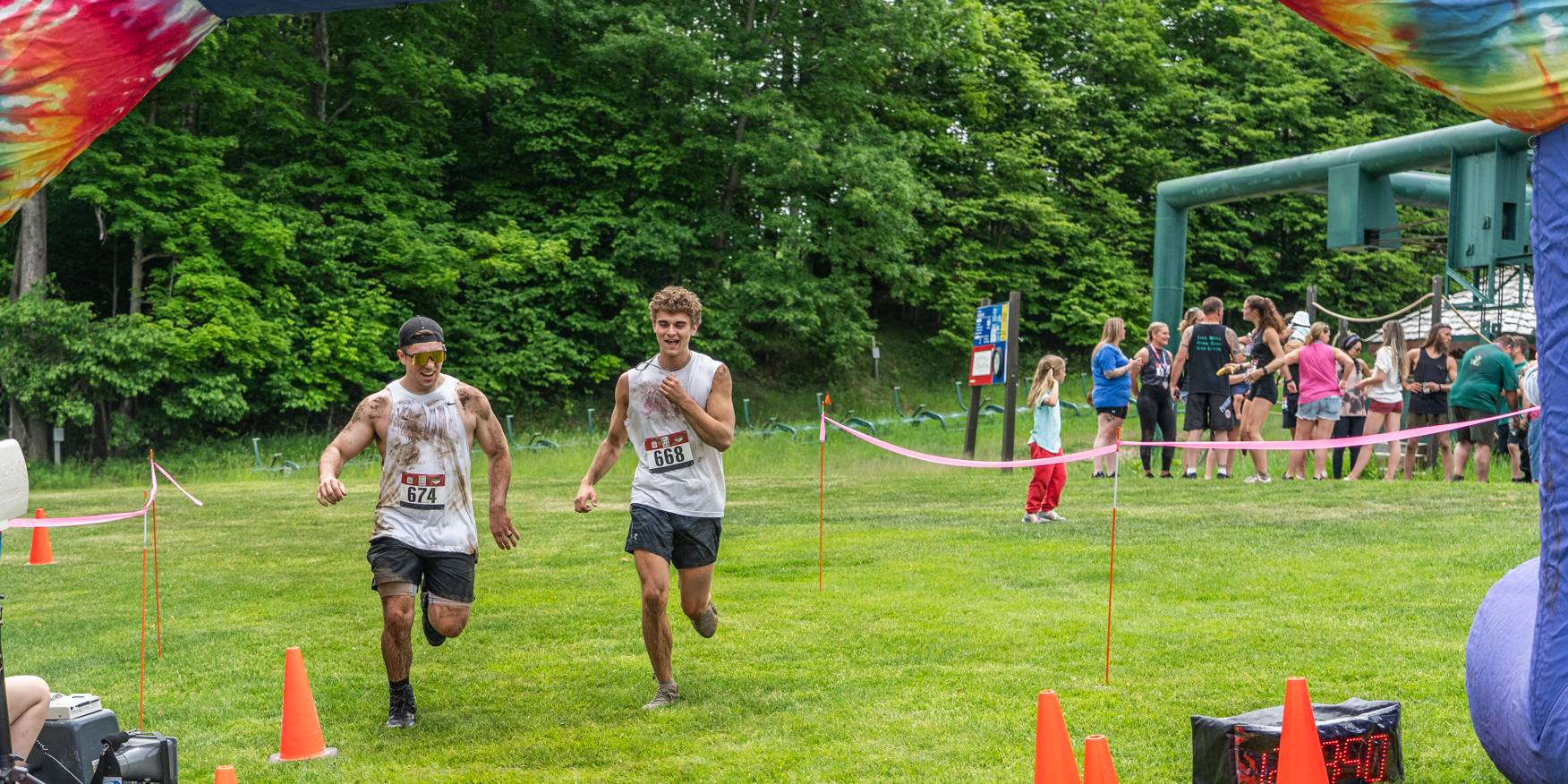 Two guys running through the finish line of the Dirty Dog Dash.