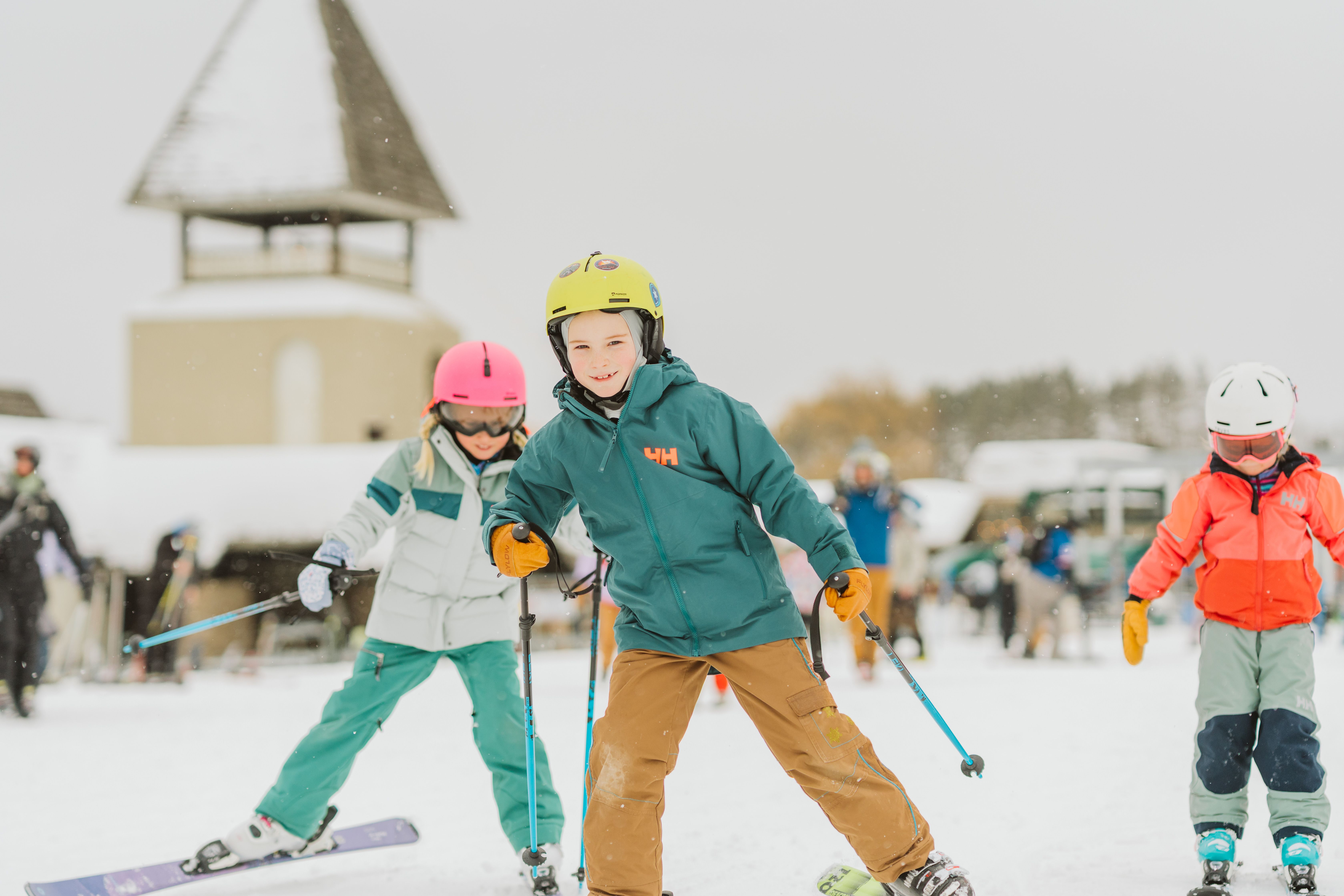 three children skiing at the base being led by a little boy