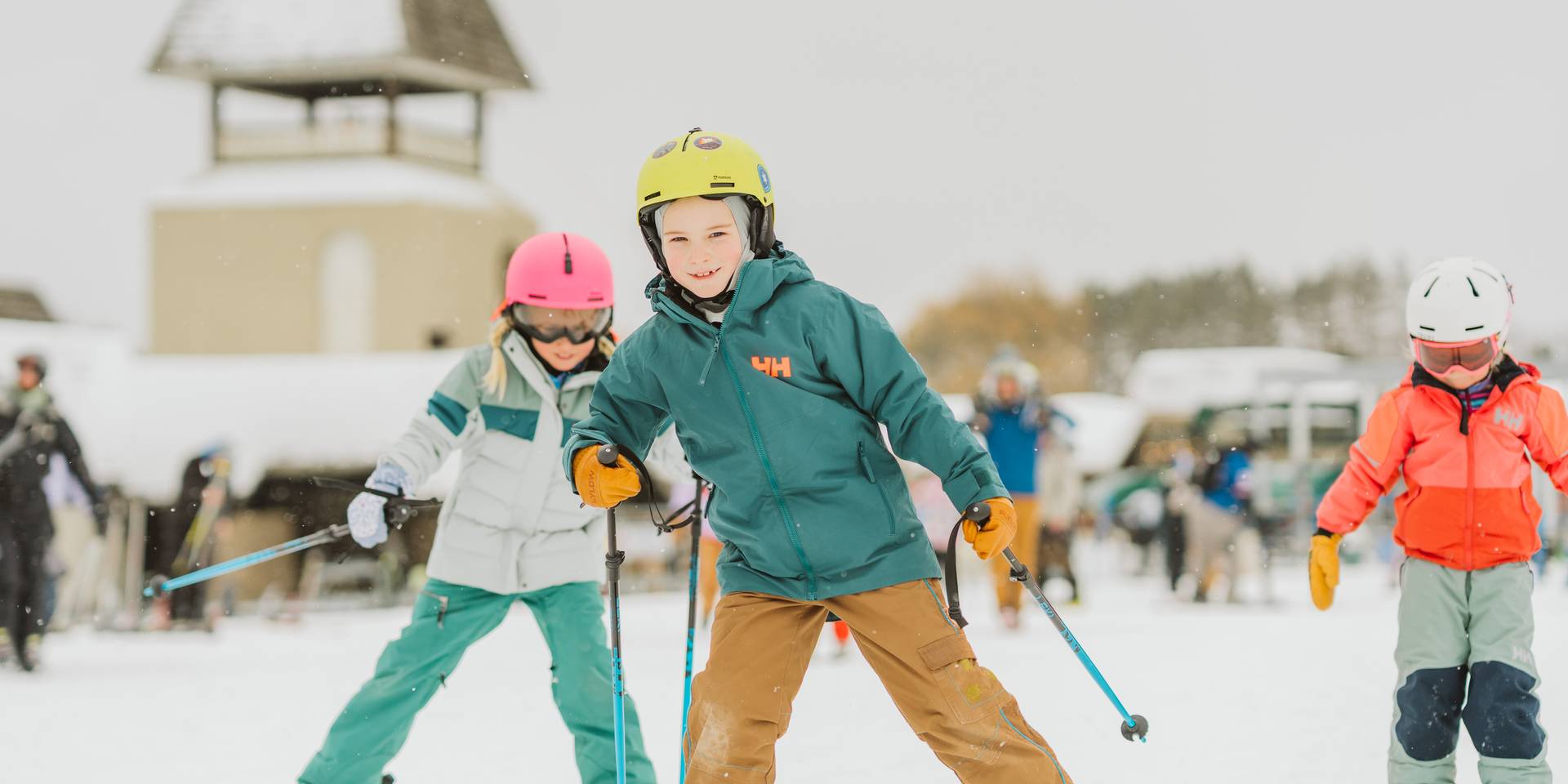 three children skiing at the base being led by a little boy