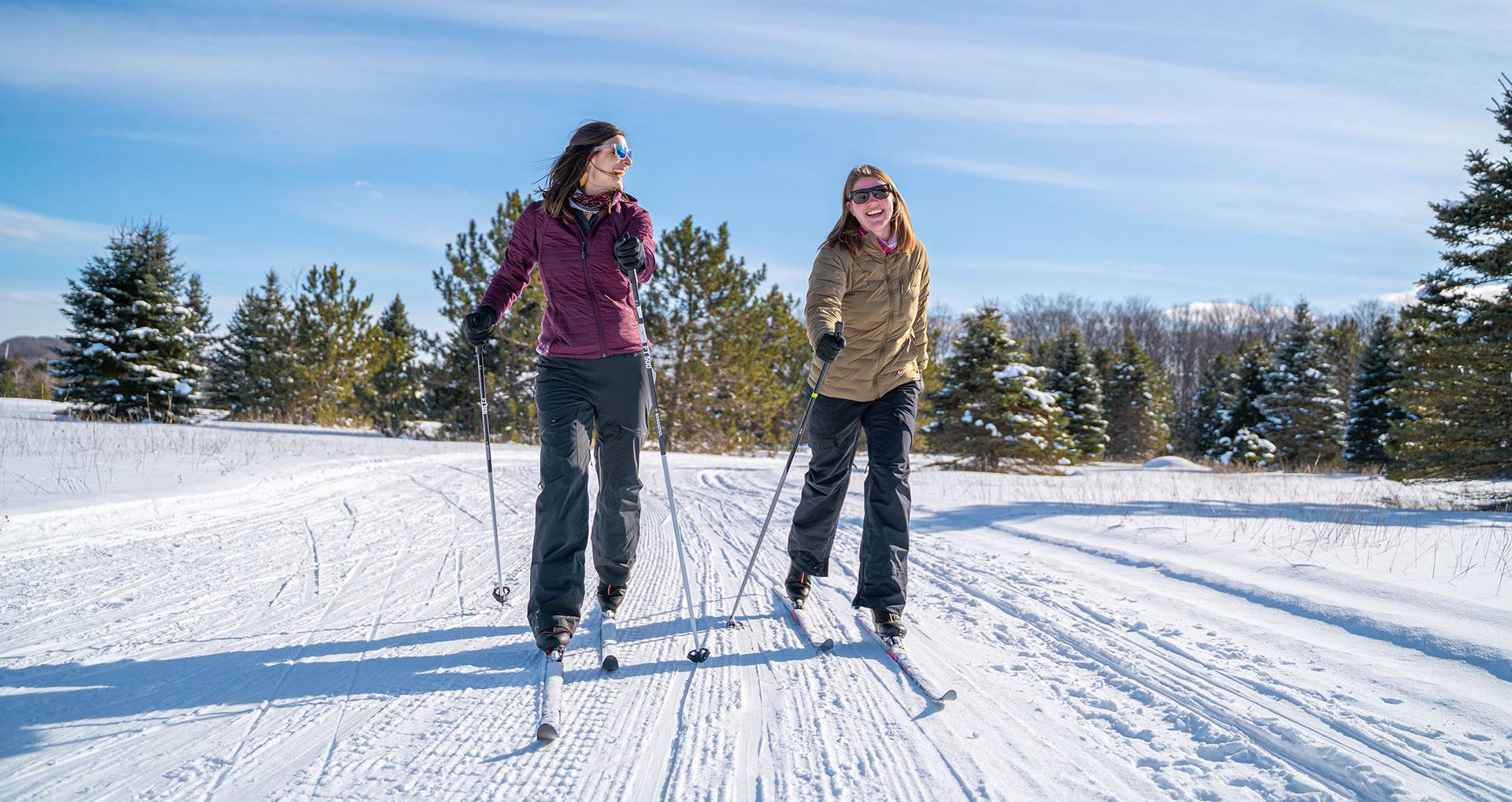 Two ladies cross country skiing down the trail