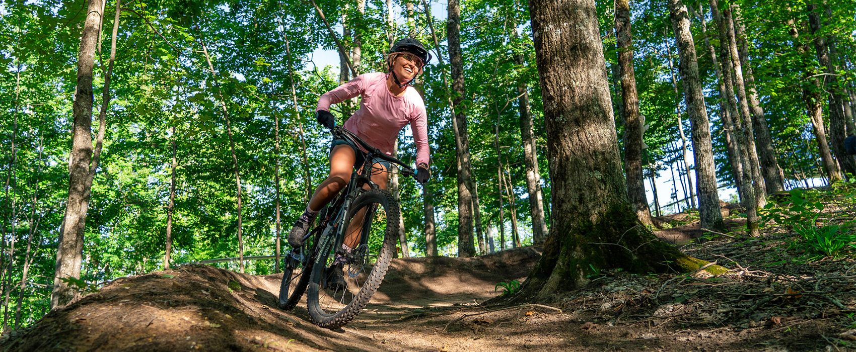 Woman mountain biking through the woods
