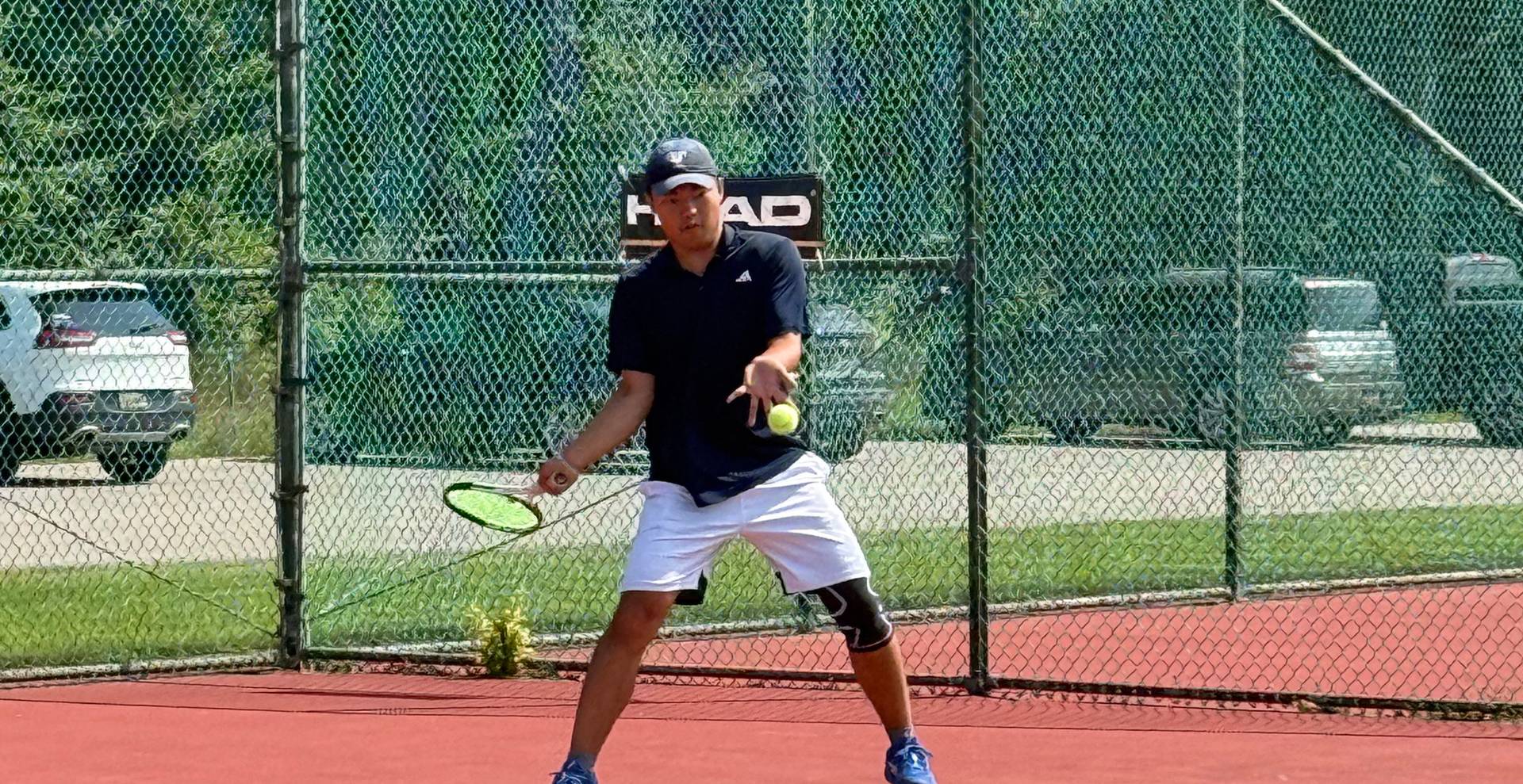 Guy about to hit the tennis ball