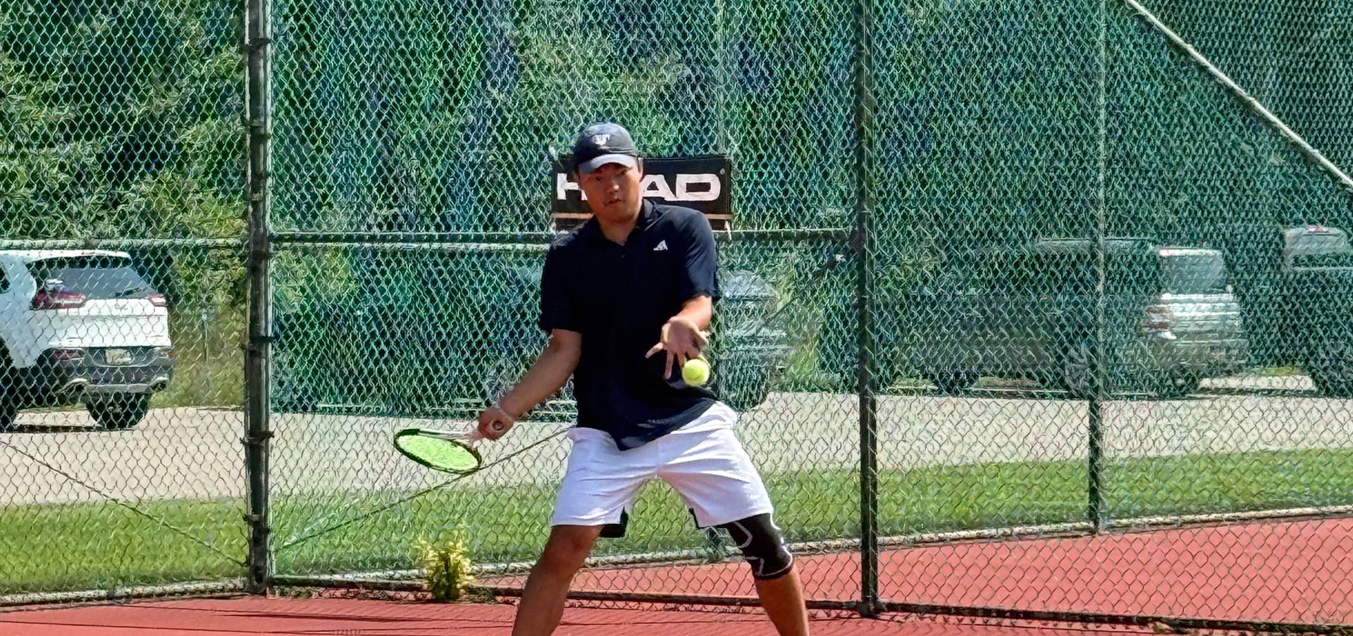 Guy about to hit the tennis ball