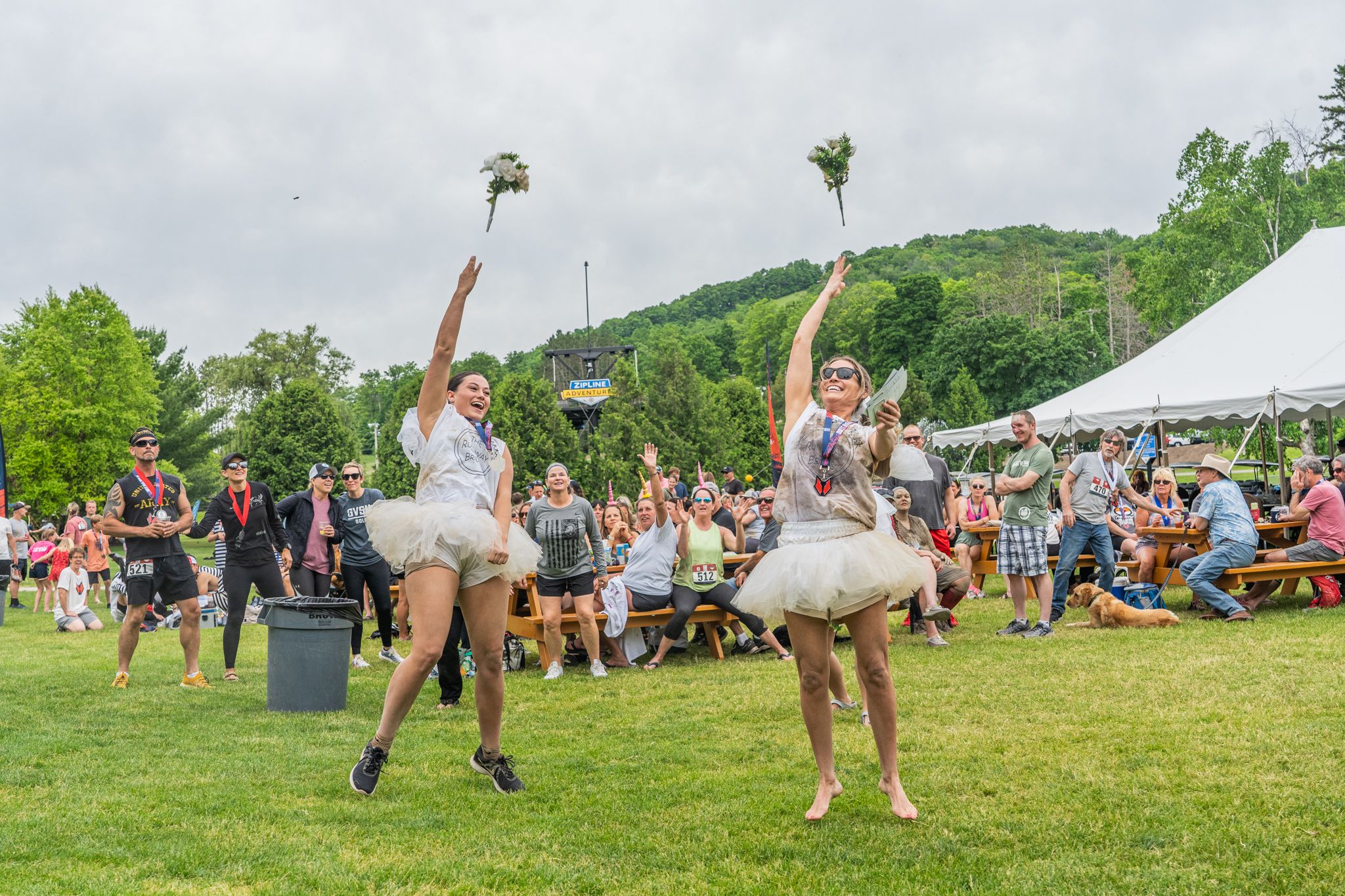 Racers dressed as brides throw flowers into the crowd