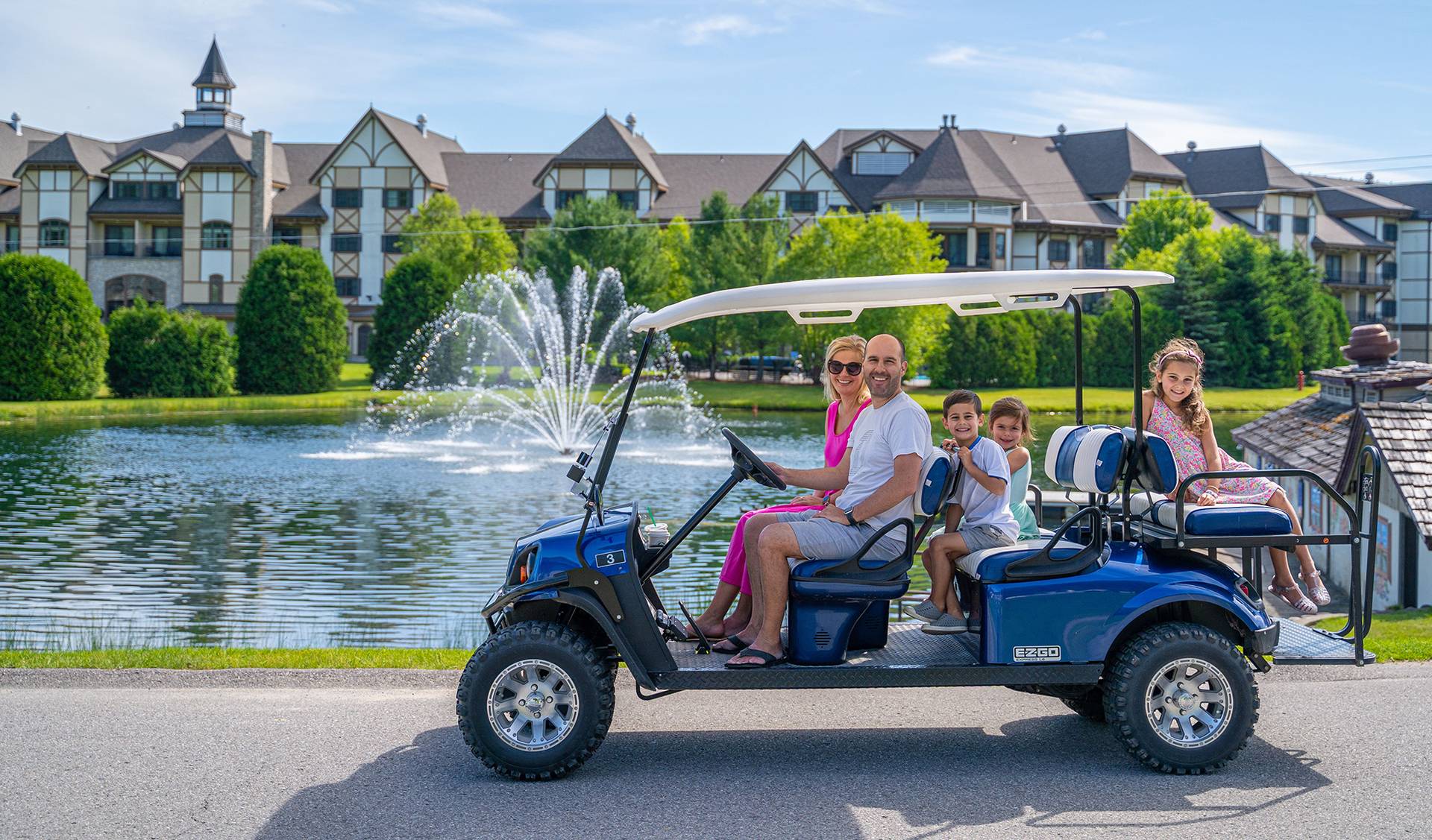 Family on scenic carts near pond.