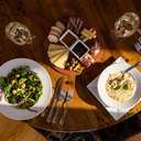 Spread of food at Stein Eriksen's showing a cheese board, salad, and chowder.