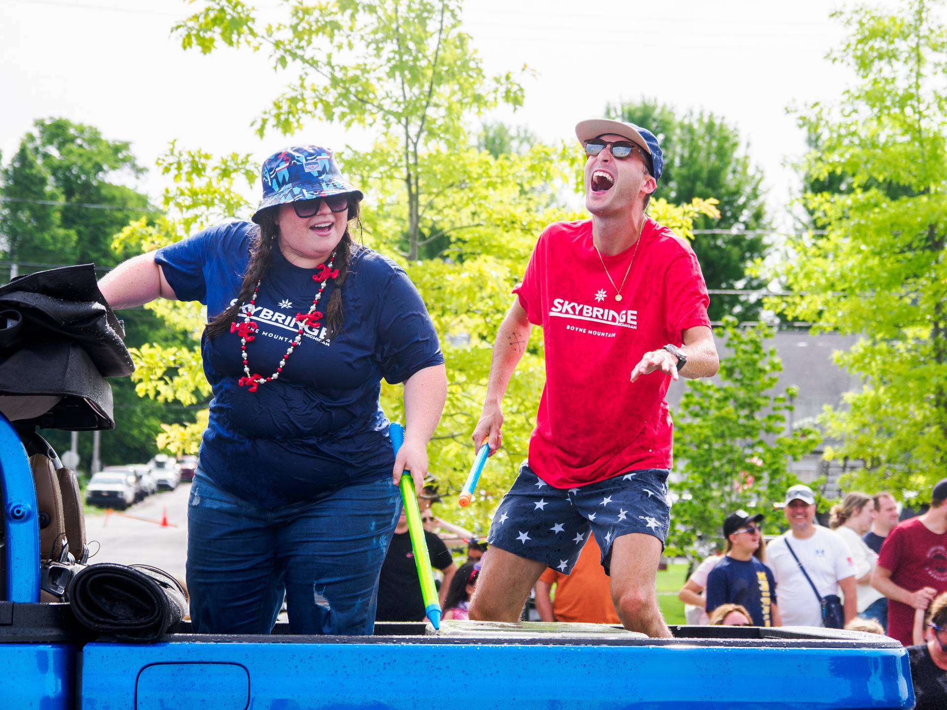 Two people smiling after getting sprayed with water gun