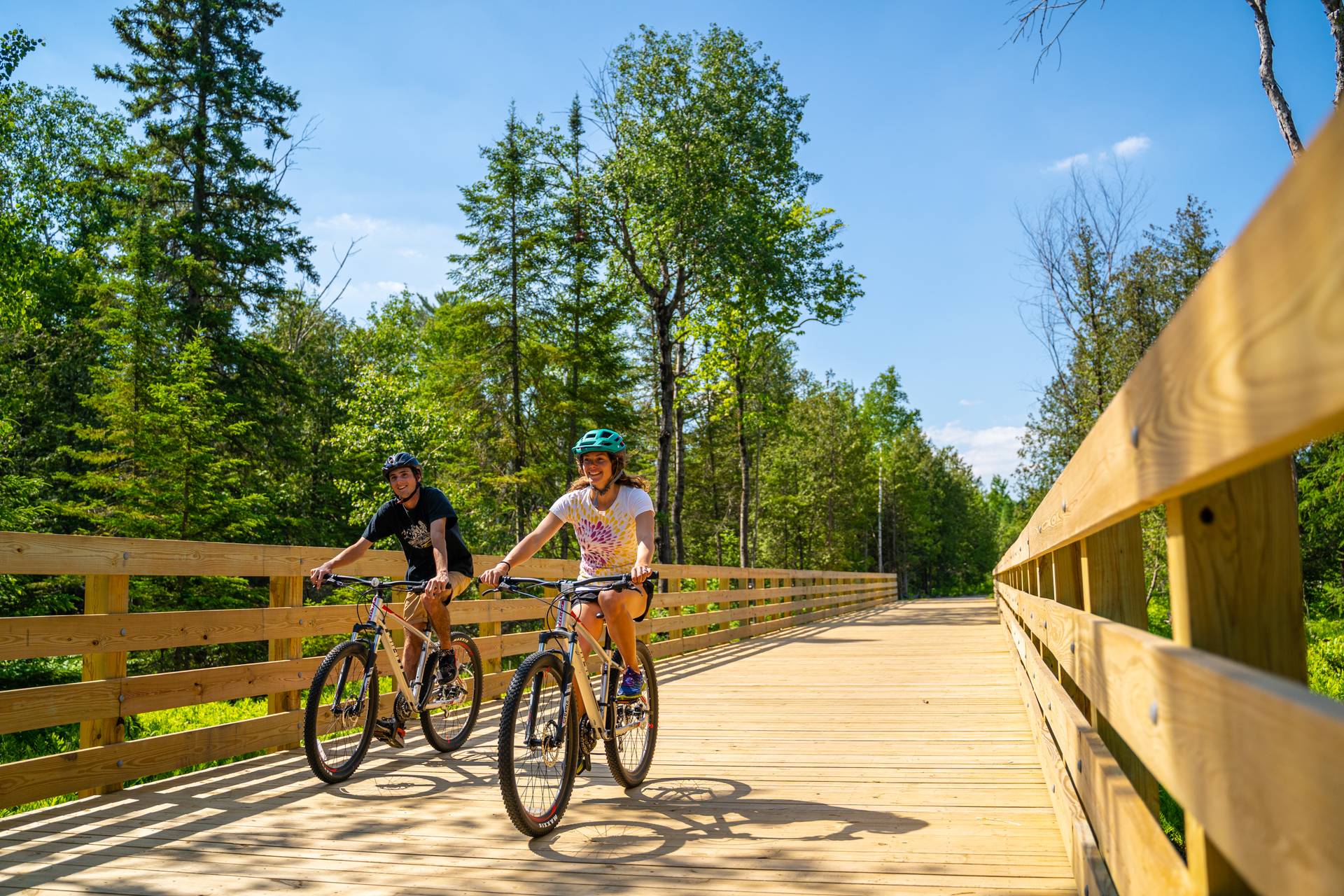 Two people biking on Boyne Valley Trail and smiling