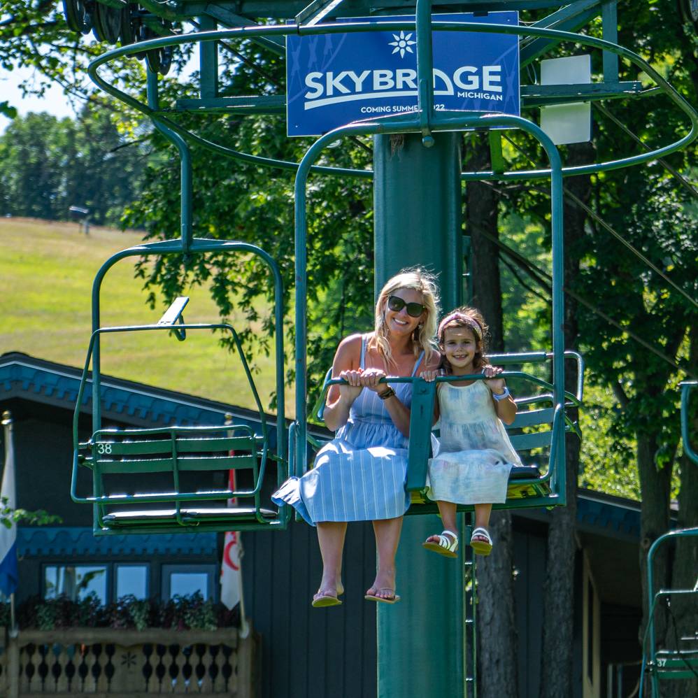 Mother and daughter riding up the Hemlock scenic chairlift
