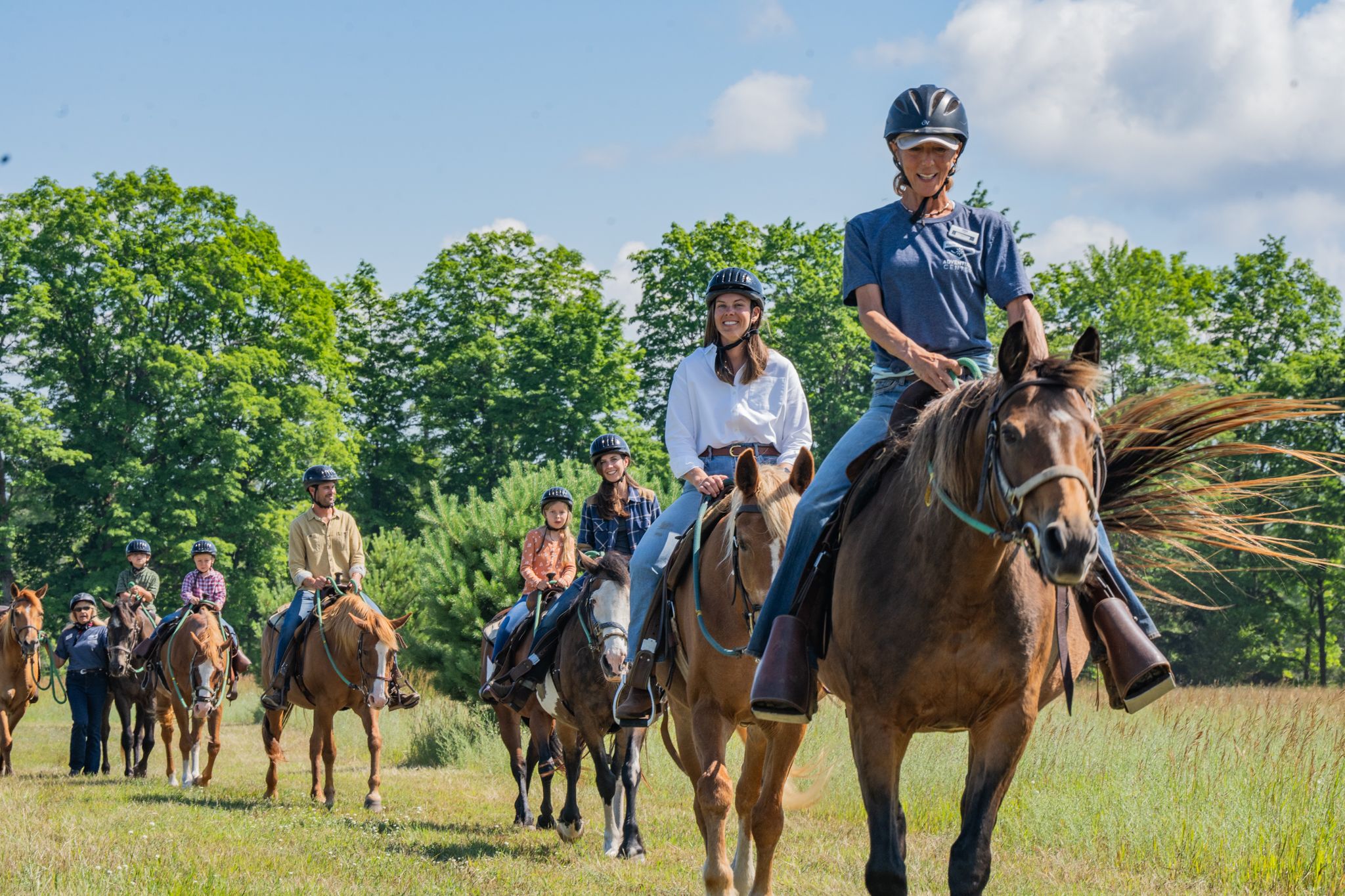 Horse wrangler leading group on trail ride