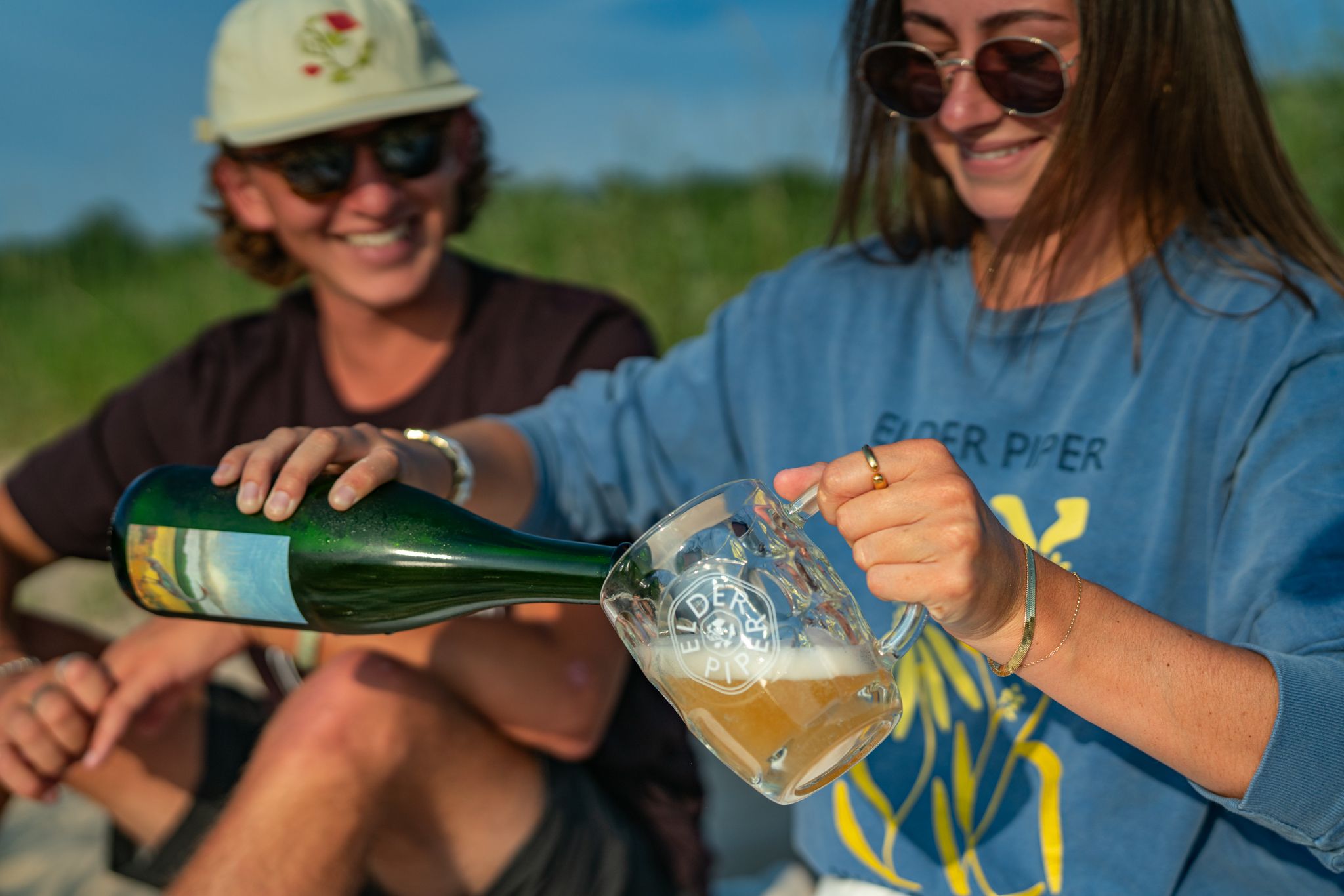 couple pouring beer on the beach