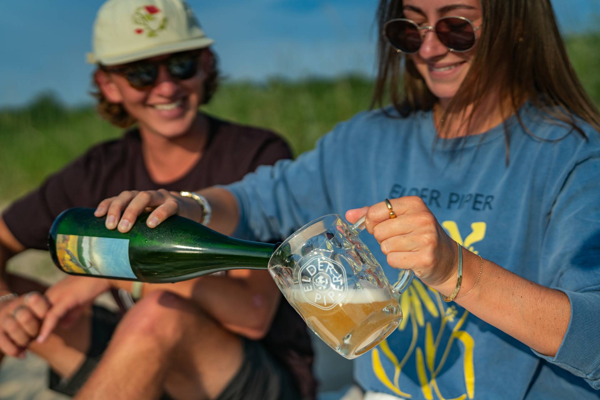 couple pouring beer on the beach