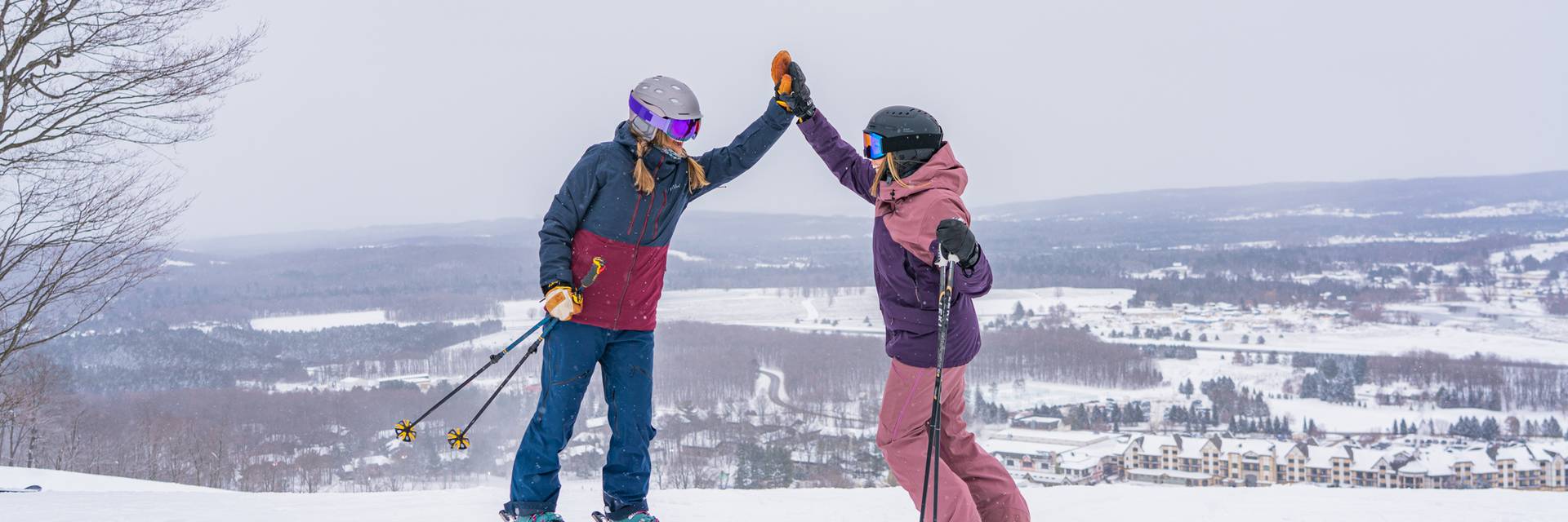 Two skiers at the top of the mountain high fiving