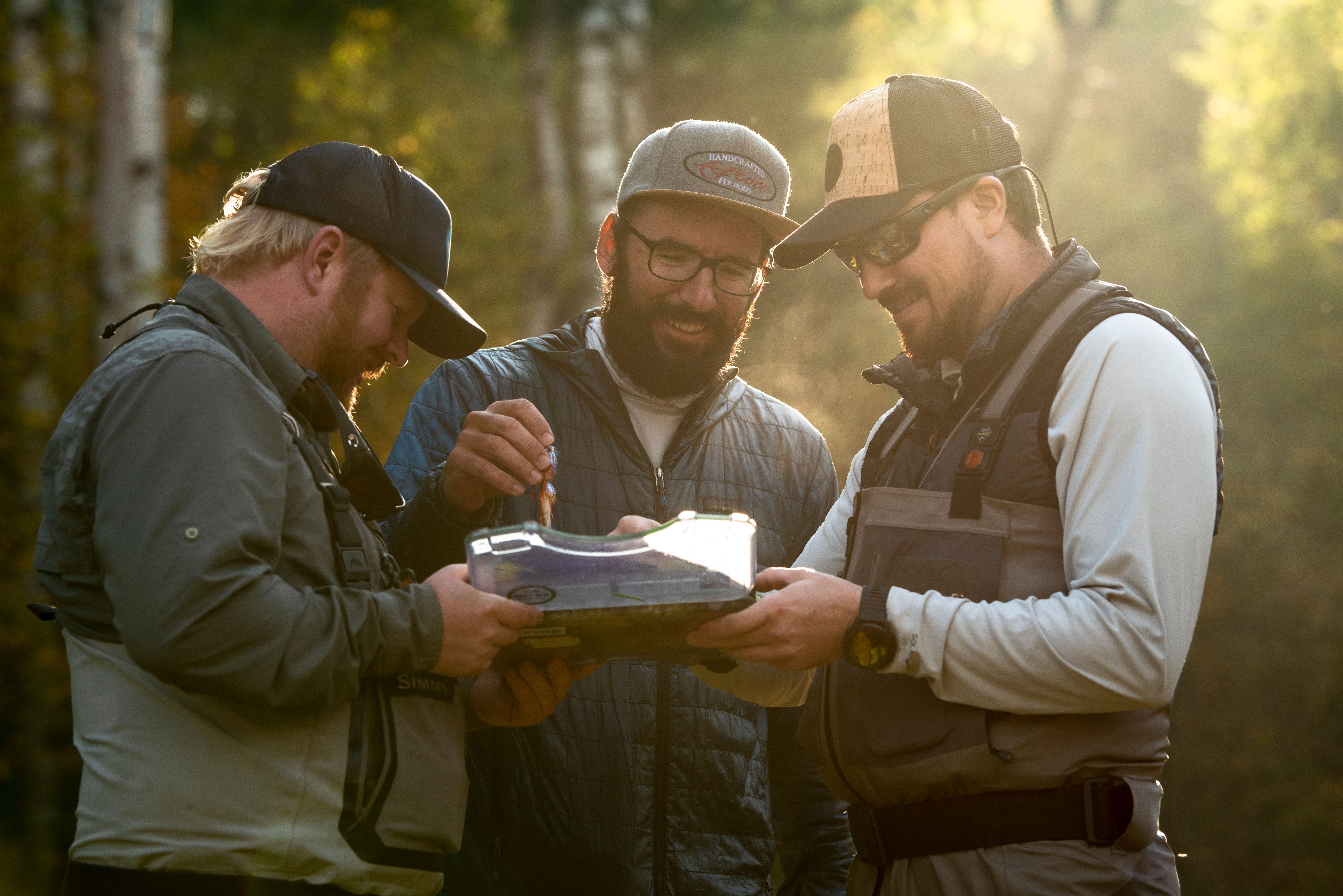 Guys laughing and picking out flys before fishing.