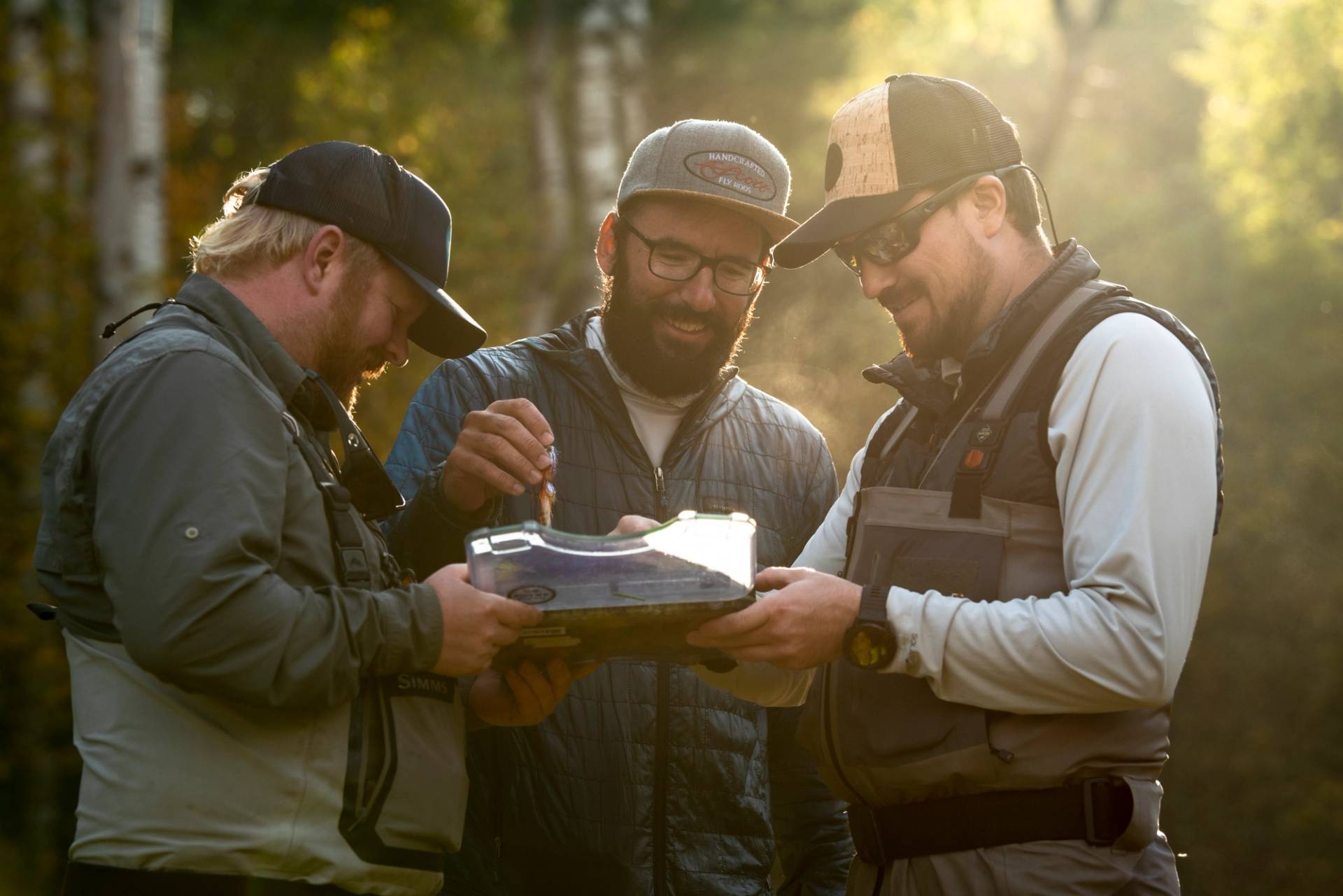 Guys laughing and picking out flys before fishing 