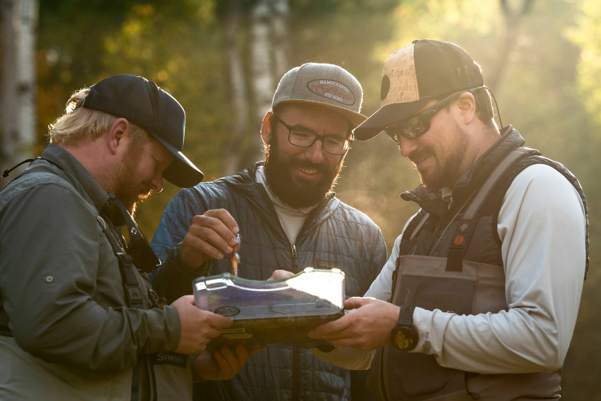 Guys laughing and picking out flys before fishing.