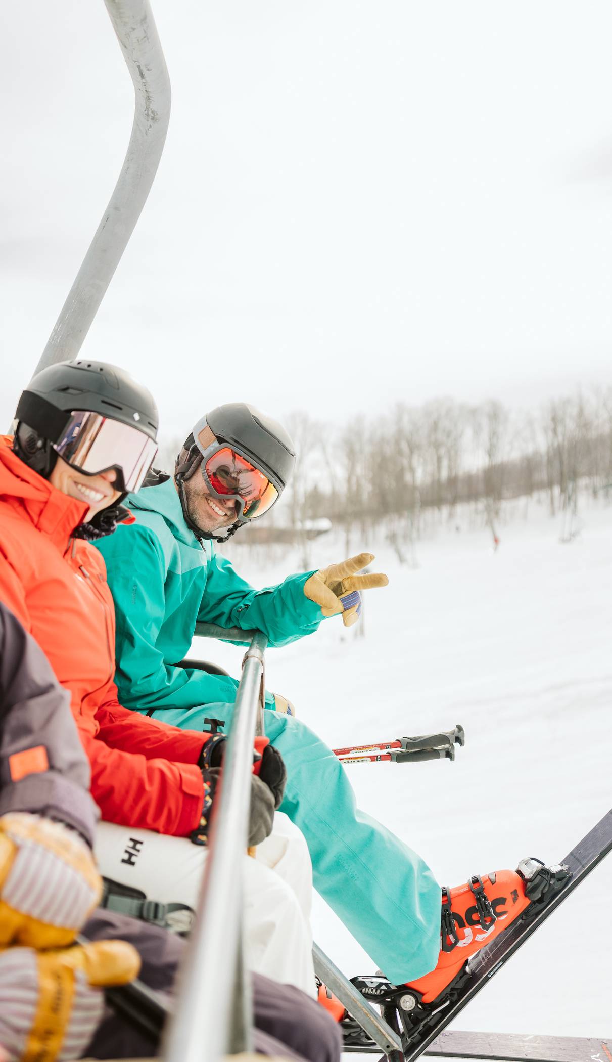 two skiers riding chairlift