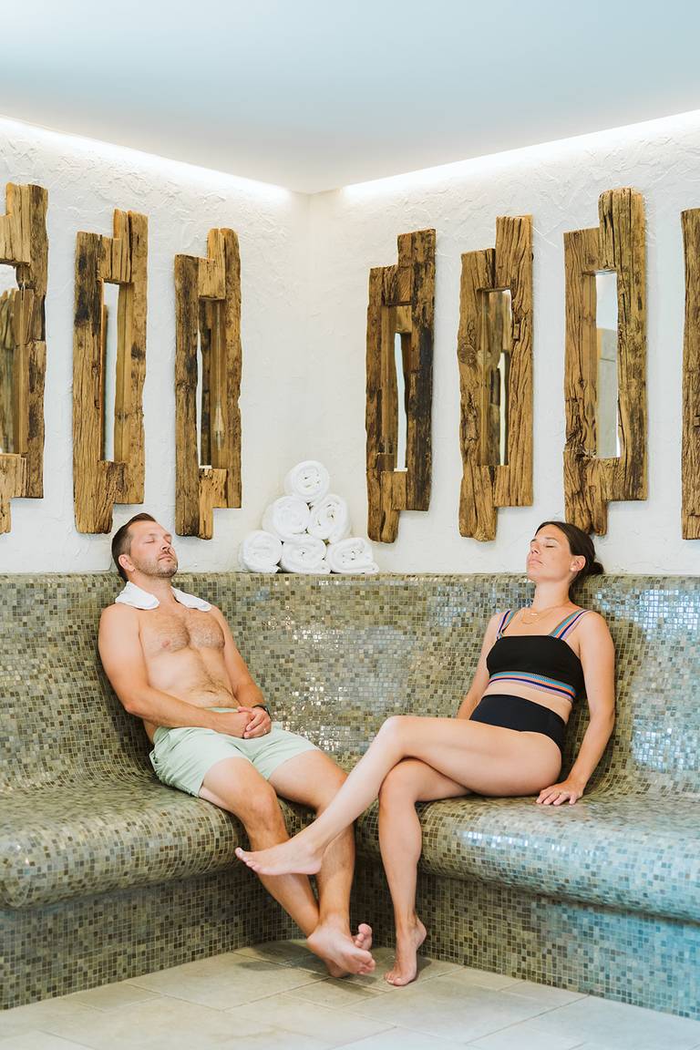 Couple relaxing on tile bench in the nordica cirque sauna