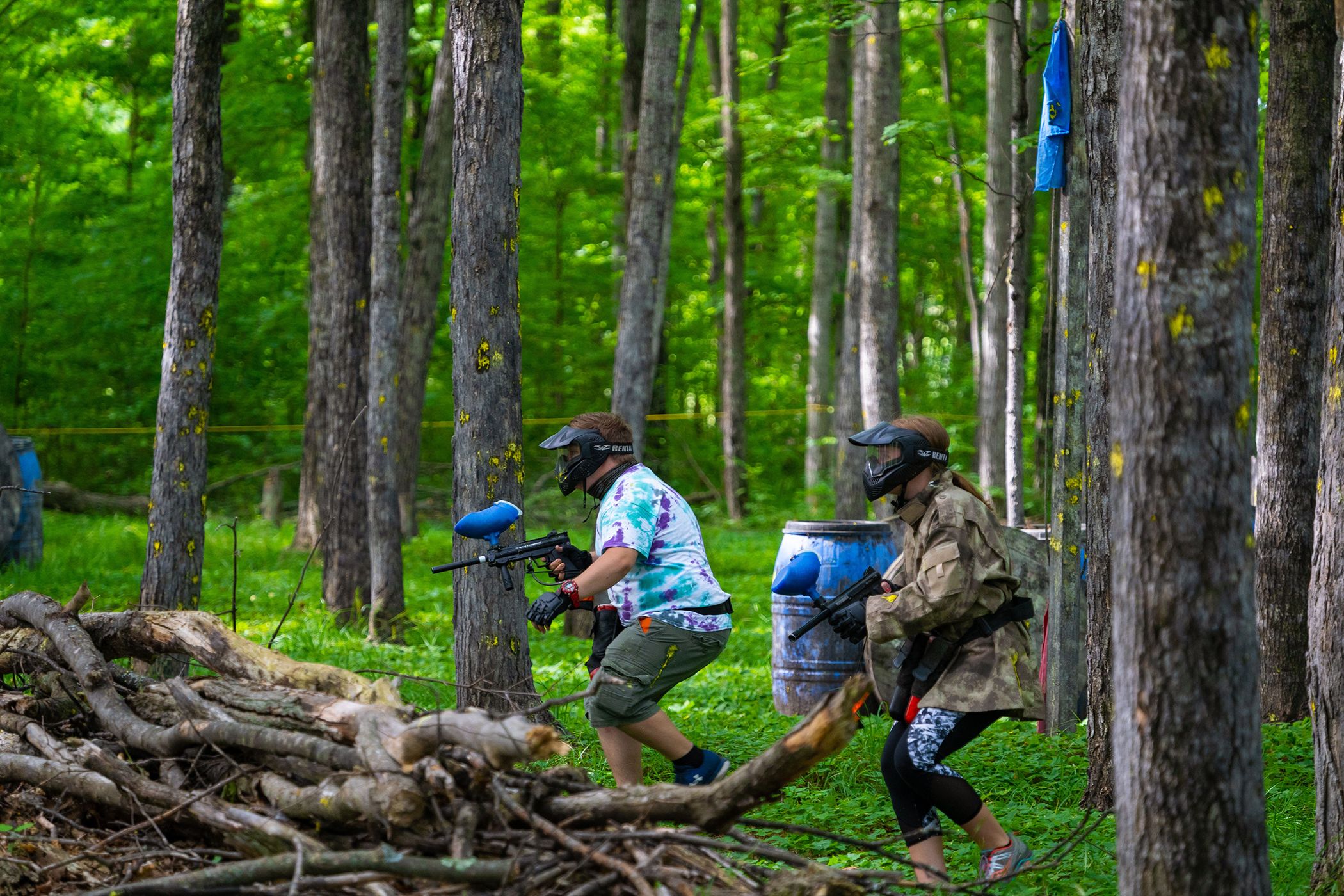Two men in on the hunt for opponents with paintball guns.