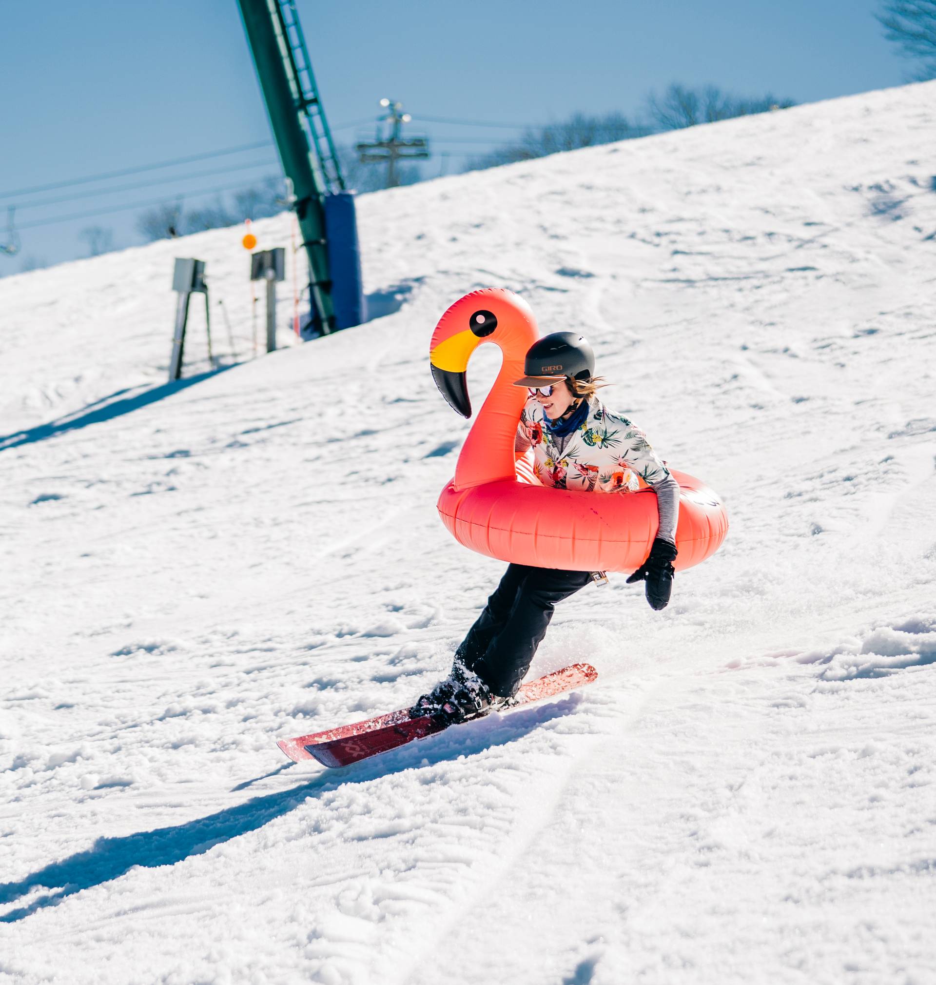 Guy skiing with flamingo tube around him