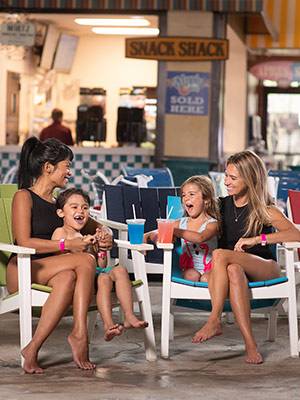 Moms with daughter and son on chairs with slushies