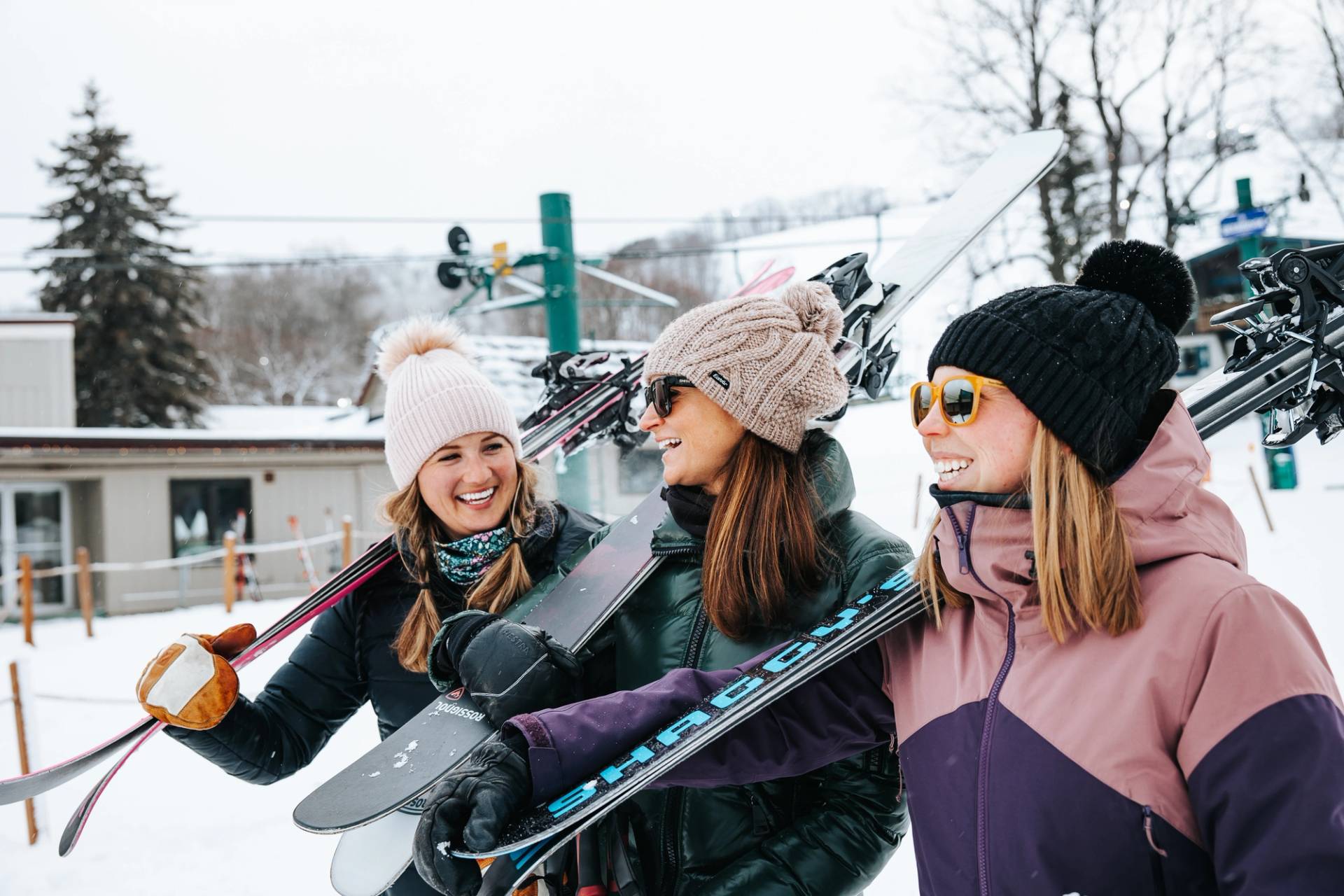 girls carrying skis