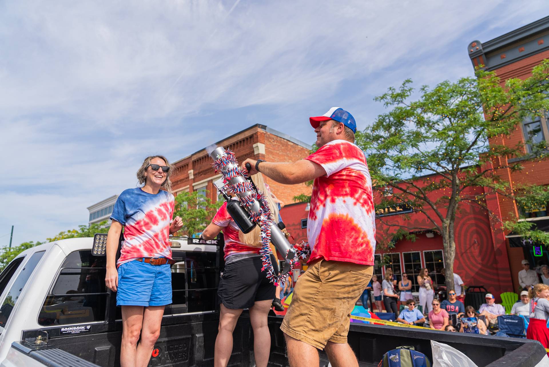 Person using shirt cannon on parade truck