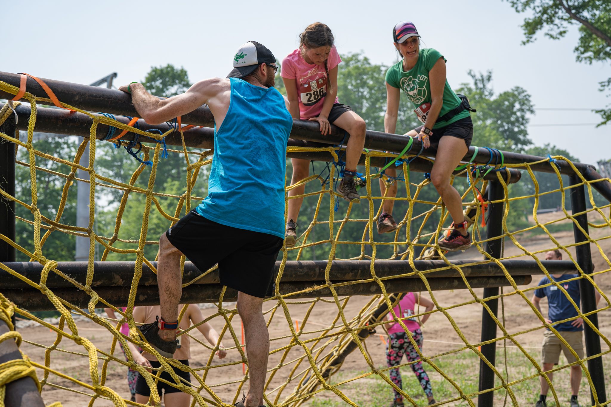 racers climbing over rope obstacle