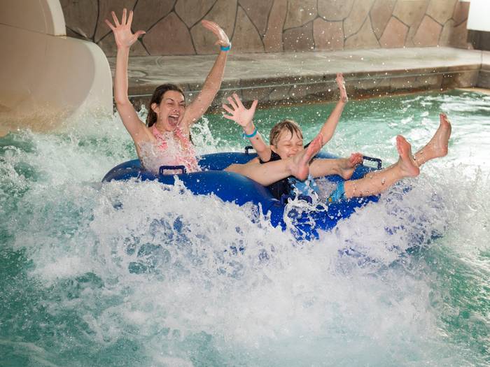Guests riding tube out of the end of a waterslide