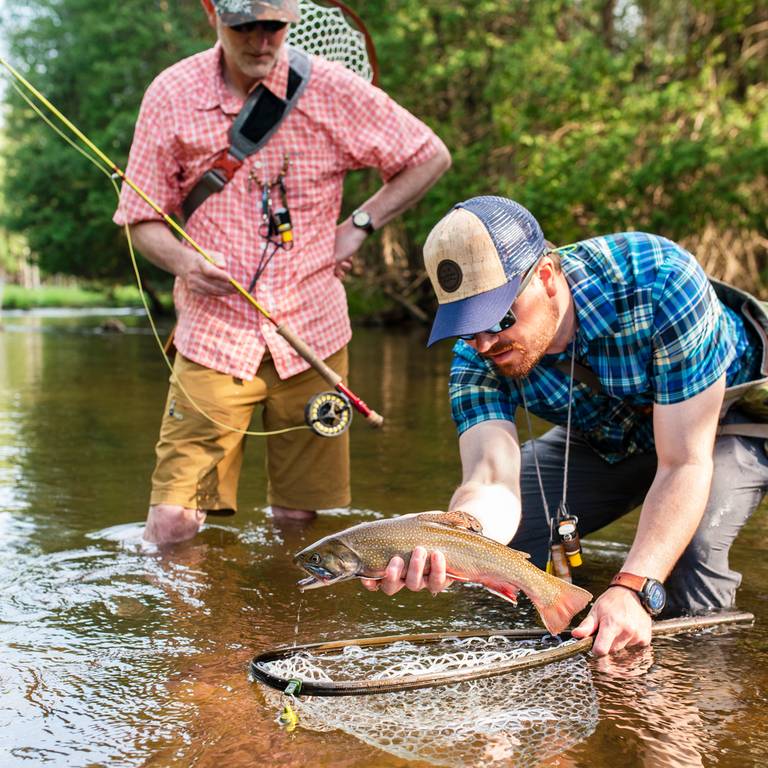 two guys fishing on a river