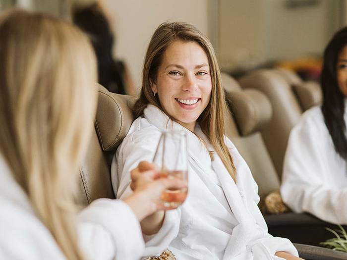 Women toasting champagne while getting pedicures at The Spa