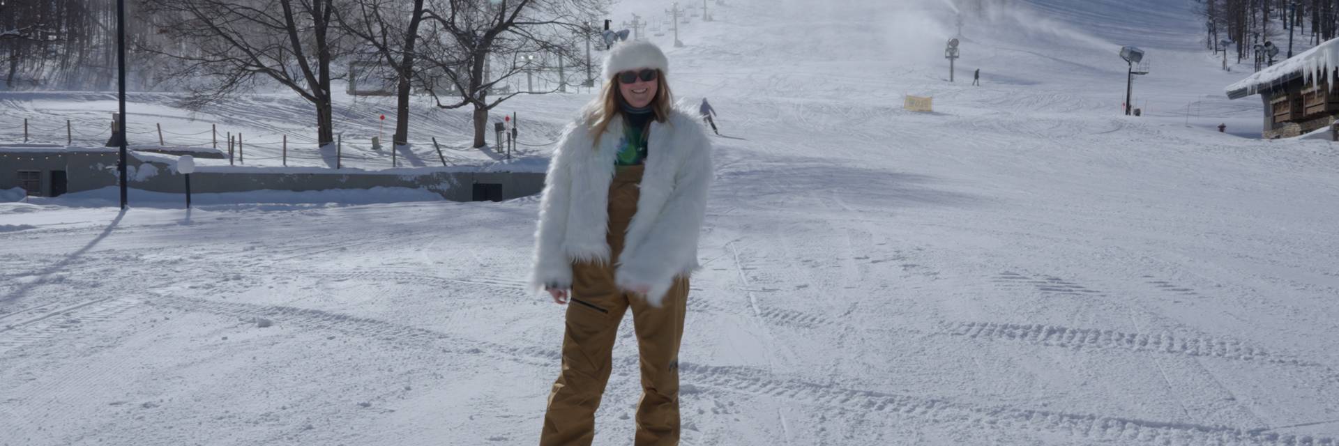 Woman standing at the base of Mountain in fir coat