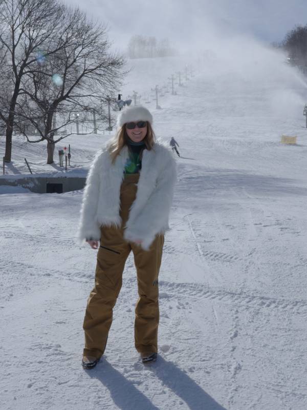 Woman standing at the base of Mountain in fir coat