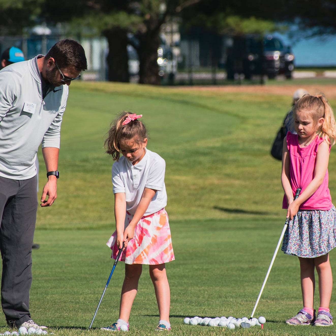Two girls getting golf instruction