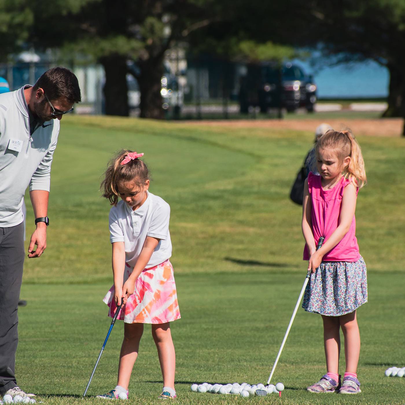 Two girls getting golf instruction