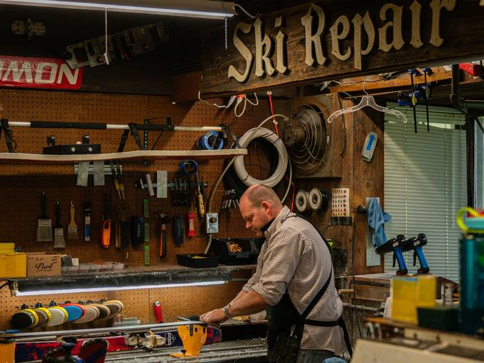 Tune shop employee working on a pair of skis