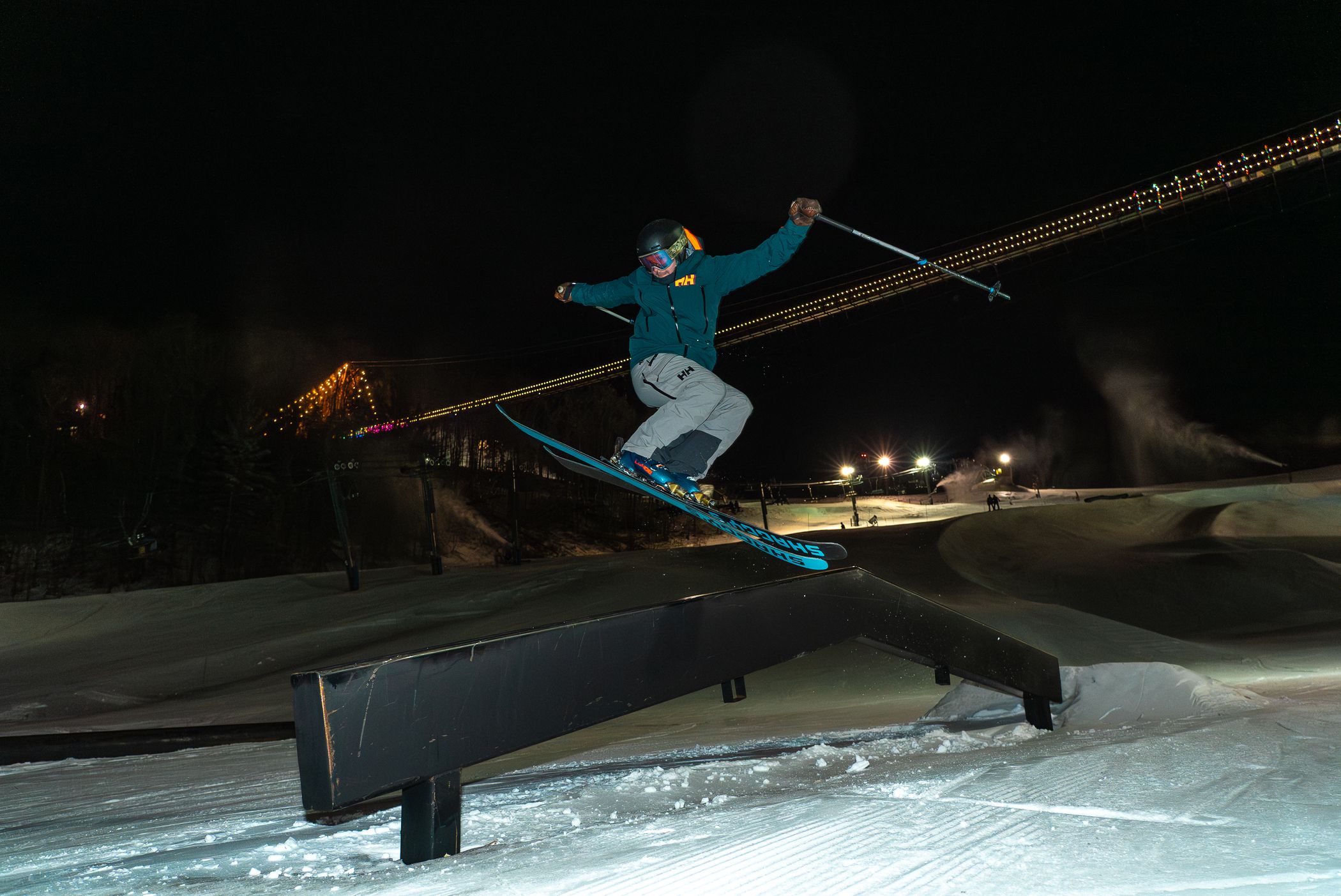 Skier riding the rails in the terrian park at night