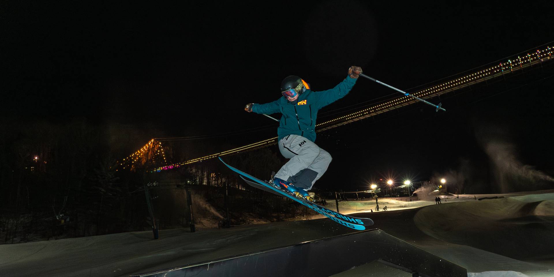 Skier riding the rails in the terrian park at night