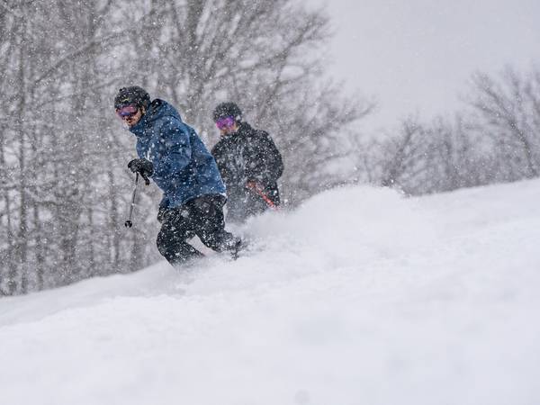 skiers riding in a snow storm